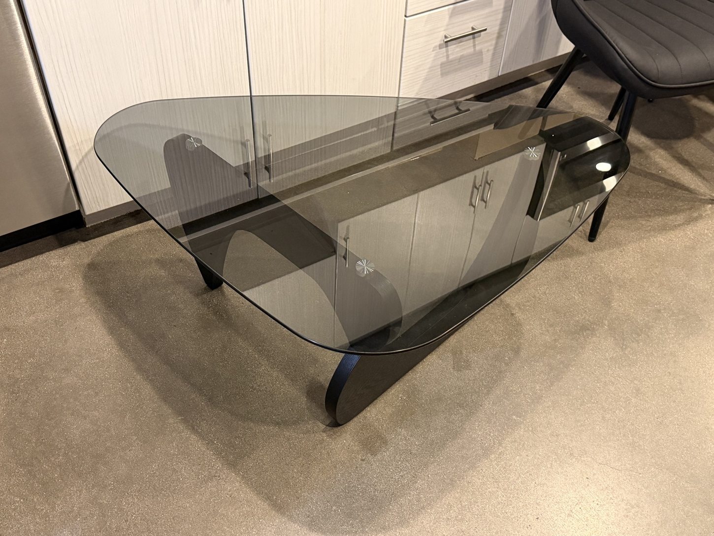 Curved black base and smoked glass top coffee table assembled by BoxBuilt