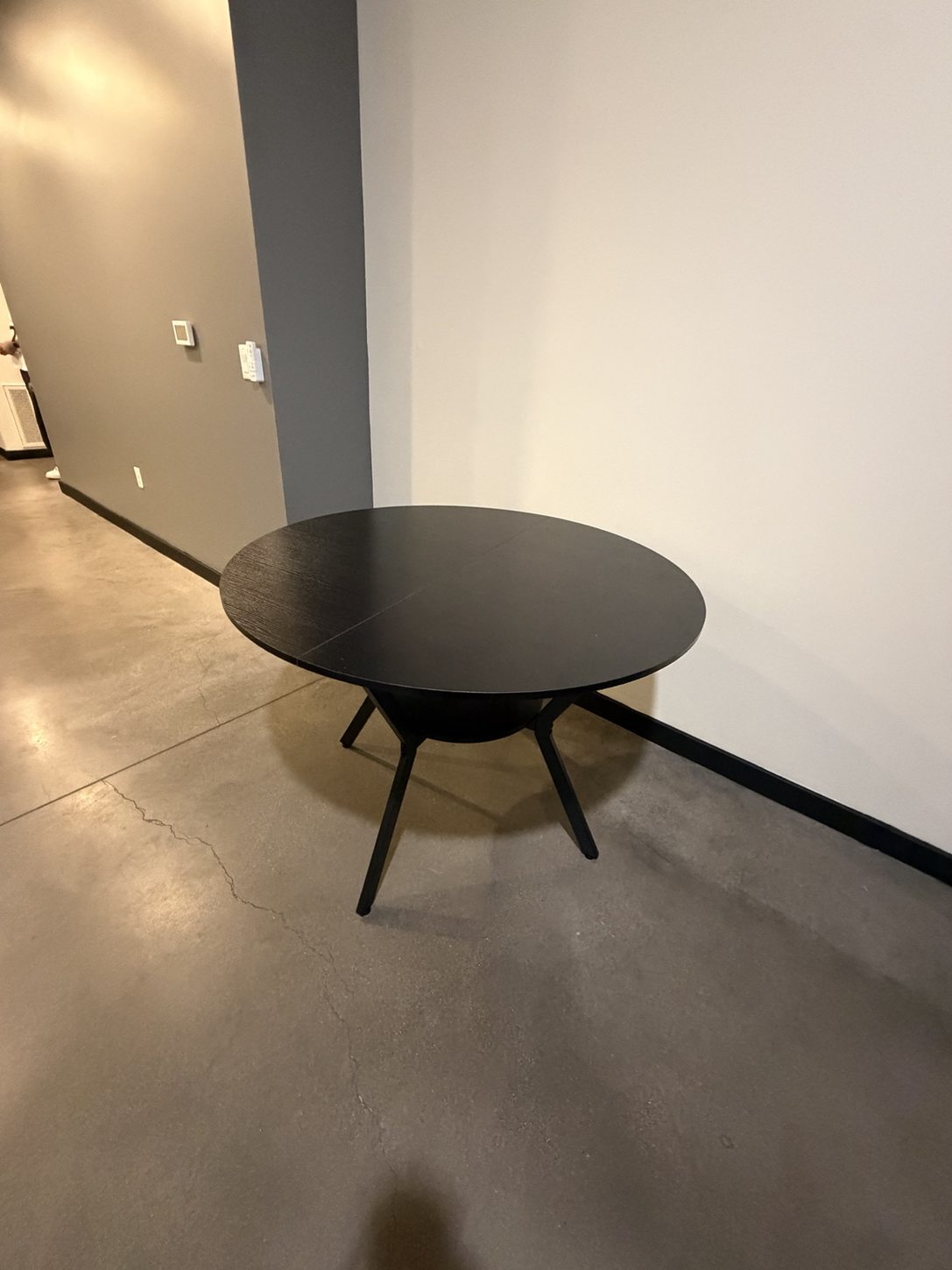 Finished black round dining table with tapered legs