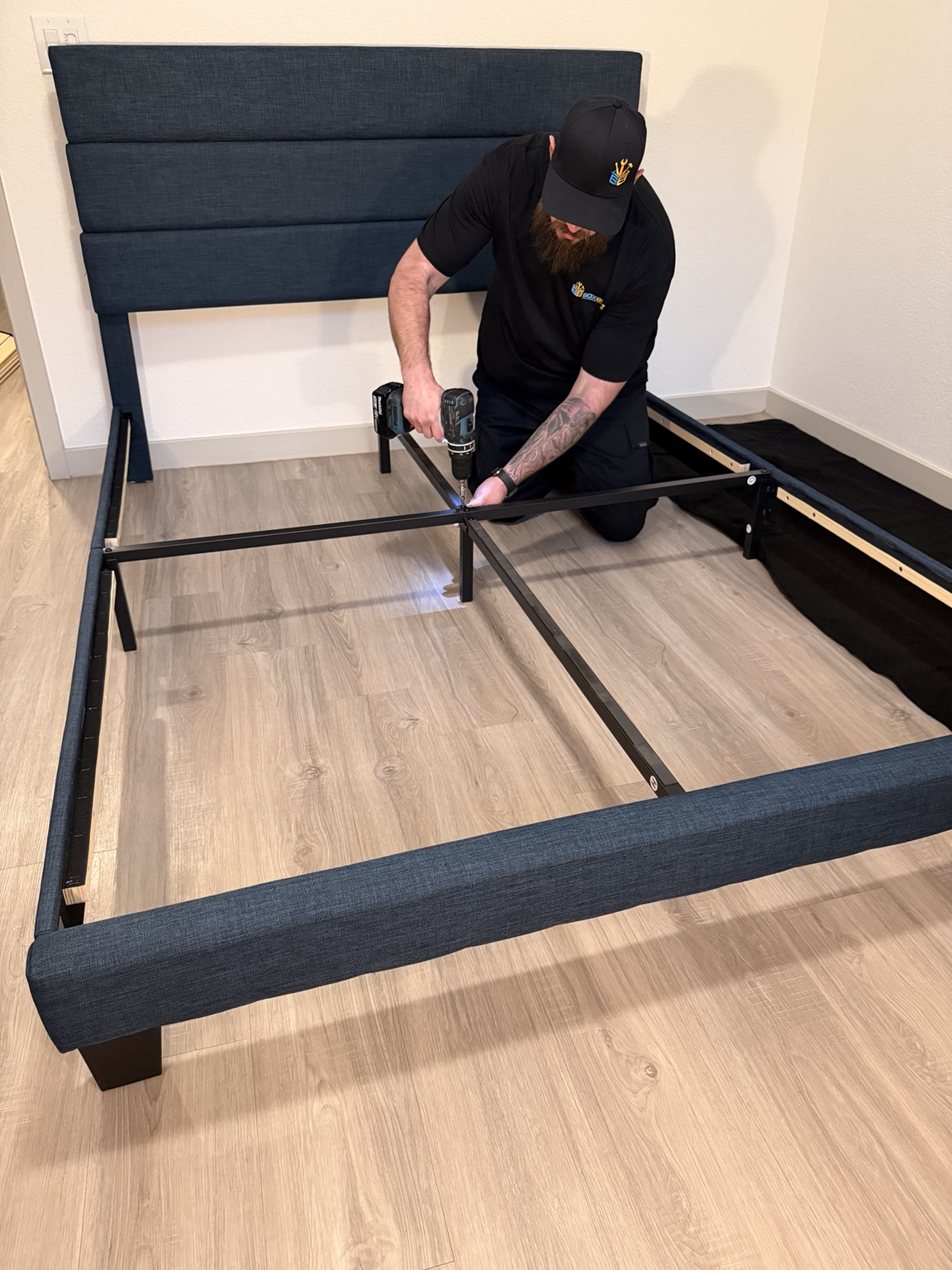 Jim from BoxBuilt carefully fastening a bed frame in a real assembly demonstration